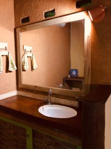 a bathroom with a sink and a large mirror at Cabana Rio in Ilhabela