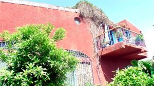 un edificio rojo con una escalera en el lateral en Fabuleuse Villa Keur Bibou en Dakar