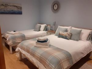 um quarto com duas camas e uma mesa em Coast 77 B&B em Poole