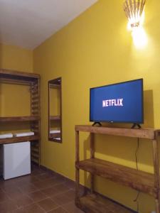 uma sala de estar com televisão numa mesa em Bahia Mar Pousada - sob nova direção em Arraial d'Ajuda