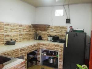 a kitchen with a black refrigerator and a brick wall at Fonda la Legia in Los Andes
