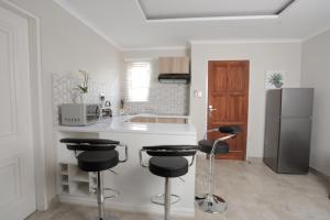 
a kitchen with a refrigerator, sink and a microwave at Lefa Boutique Hotel in Rustenburg
