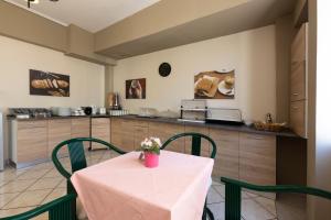 a kitchen with a table with green chairs and a counter at Filon in Piraeus