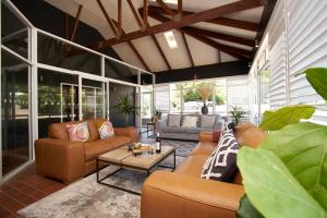 a living room with couches and a table at Country Comfort Armidale in Armidale