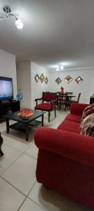 a living room with a red couch and a table at DEPARTAMENTO POR DÍA EN LA CIUDAD DE ARICA. in Arica