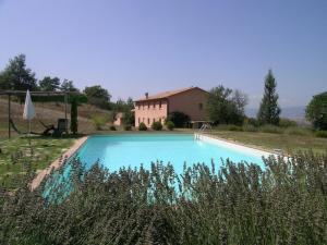 a large blue swimming pool in front of a house at Villa Le Terme in San Casciano dei Bagni
