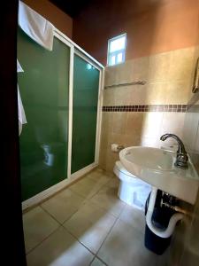 een badkamer met een toilet, een wastafel en een douche bij La Finca del Abuelo Teotihuacan in San Juan Teotihuacán