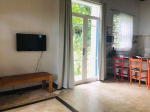 a living room with a television and a table with chairs at Casa Praia da Vila in Ilhabela