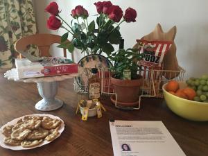 Charming home in Derby city في لويزفيل: طاولة مع الزهور وصحن من الكعك عليها
