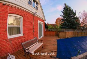 多倫多的住宿－Comfort Home Toronto，砖砌建筑旁的木甲板,带长凳