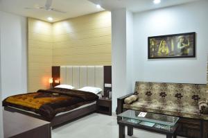 a bedroom with a bed and a couch at Hotel Popular in Amritsar +84 photos