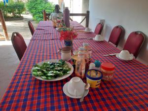 a table with a plate of food and a plate of greens at Ames Nungwi in Nungwi