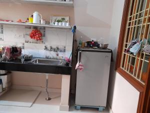 a small kitchen with a sink and a refrigerator at Govind Niwas Home Stay in Gwalior