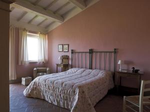 サン・カシャーノ・デイ・バーニにあるVilla Le Termeのピンクの壁に大きなベッドが備わるベッドルーム1室