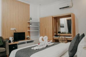 a bedroom with a bed with a towel animal on it at Sea Terras Suite and Luxury in Nusa Penida