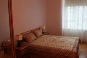 1 dormitorio con 1 cama con 2 lámparas y espejo en Old Riga Apartment, en Riga