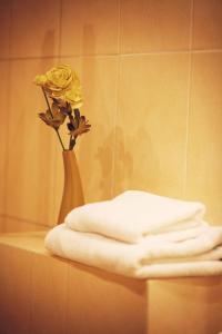 a vase with a yellow flower sitting on a table at Hotel Zorza in Namysłów