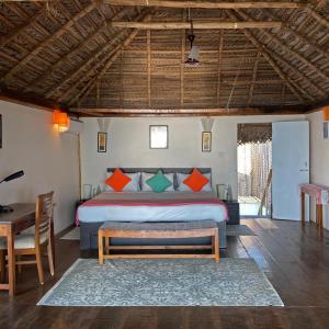 a bedroom with a bed and a table and a desk at Agonda Villas in Agonda