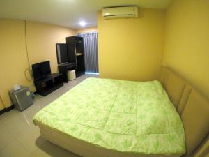 - une chambre avec un lit et une télévision dans l'établissement The One, à Phayao
