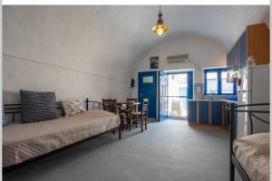 a living room with a couch and a table and a kitchen at easy going santorini house in Éxo Goniá