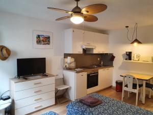 a small kitchen with a desk and a table with a television at Oranger in Nice