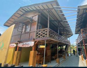 ein Holzgebäude mit Balkon auf einer Straße in der Unterkunft Arya's Surf Camp in Sukabumi