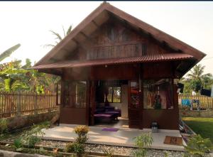 a small house with a thatched roof at Arya's Surf Camp Cimaja in Sukabumi