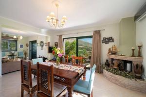 a dining room with a table and a fireplace at Villa Hara in Agia Effimia