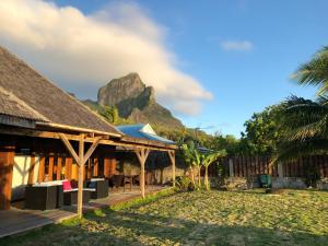 ein Resort mit einem Berg im Hintergrund in der Unterkunft Bora Bora waterfront sunrise villa in Bora Bora