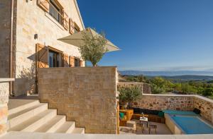 una casa con una pared de piedra y una piscina en Design Villa Mar Hvar Island en Pitve