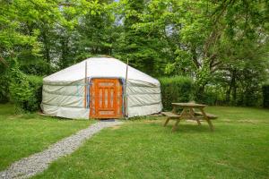 a yurt with a picnic table and a picnic table at Le Village Insolite yourte et roulotte in Saint-Benoît-des-Ondes