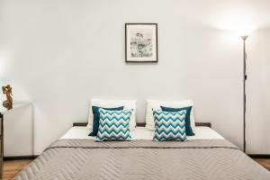 トリヤッチにあるFamily Travel Apartment SUTKI LIFEのベッドルーム1室(青と白の枕が備わるベッド1台付)