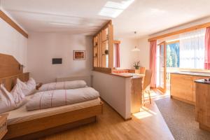 a bedroom with a bed and a desk at Residence Rogger in Dobbiaco
