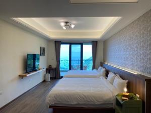 Shuilian的住宿－錦水山海莊民宿，酒店客房设有两张床和电视。