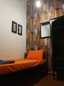 a bedroom with a bed with an orange pillow and a mirror at Great Shanghai Guesthouse in George Town