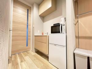 a small kitchen with a refrigerator and a microwave at HOTEL CLA-SS HIROSHIMA-DOBASHI in Hiroshima