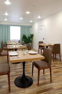 uma sala de jantar com mesas e cadeiras e uma grande janela em Бизнес-отель Nine rooms em Vladivostok