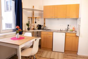 una cucina con tavolo in legno e frigorifero bianco di FULL HOUSE Studios - Blue Apartment - WiFi inkl a Magdeburgo