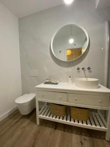 a white bathroom with a sink and a mirror at BBA Moledo - Beachfront Apartment in Moledo +29 photos