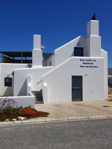 a white building with a sign on the side of it at The Loft on Malmok in Paternoster
