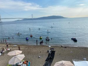 um grupo de pessoas na água em uma praia em Guesthouse Geragera em Kobe