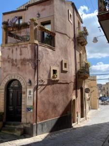 a pink building with a door and a balcony at B&B Mugnos Charme Living in Licodia Eubea