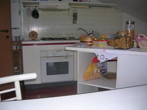 a kitchen with a stove and a counter top at Mansarda Raggio Di Sole in Verona