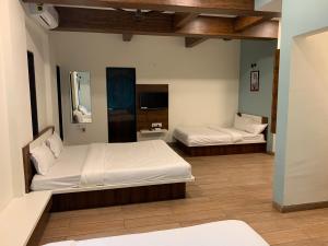 a bedroom with two beds and a tv in it at Fortune Resort in Nagaon