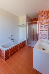 a bathroom with a bath tub and a sink at 1 logis à Domme - Piscine & SPA in Domme