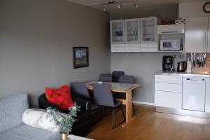 cocina y sala de estar con mesa y sillas. en Fjelltun Fritidsleiligheter, leilighet 407 en Geilo