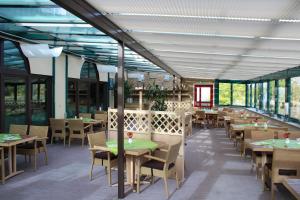 ein Restaurant mit Tischen, Stühlen und Fenstern in der Unterkunft Hotel An der Hasenheide in Bentwisch