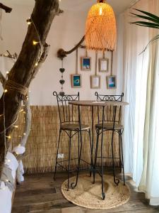 einen Tisch und zwei Stühle in einem Zimmer mit einem Baum in der Unterkunft o5sens in Agde