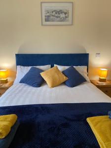 a bedroom with a blue and white bed with pillows at Moelfre B&B in Machynlleth