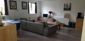 a living room with a couch and a table at Vakantiehuis B&B de Bosrand Groesbeek in Groesbeek